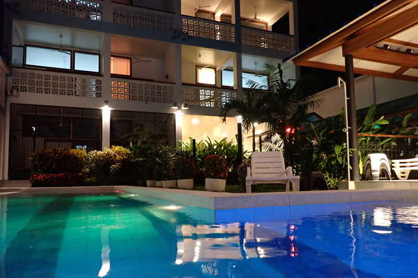 Residencial Morona Flats & Pool de noche, con piscina de 25 m y luces LED de colores, jardines tropicales, sillas largas, maloca. Flores, fragancias y grillos. Tranquilidad y privacidad.