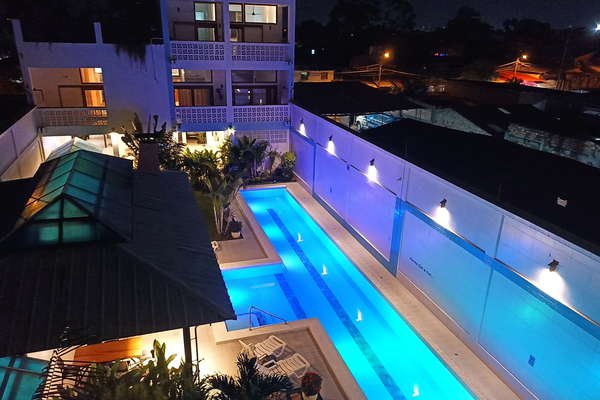 Residencial Morona Flats & Pool de noche con piscina 25 m Residencial Morona Flats & Pool de noche, con piscina de 25 m y luces LED de colores, jardines tropicales, sillas largas, maloca. Flores, fragancias y grillos. Tranquilidad y privacidad. Vista hacia la ciudad.